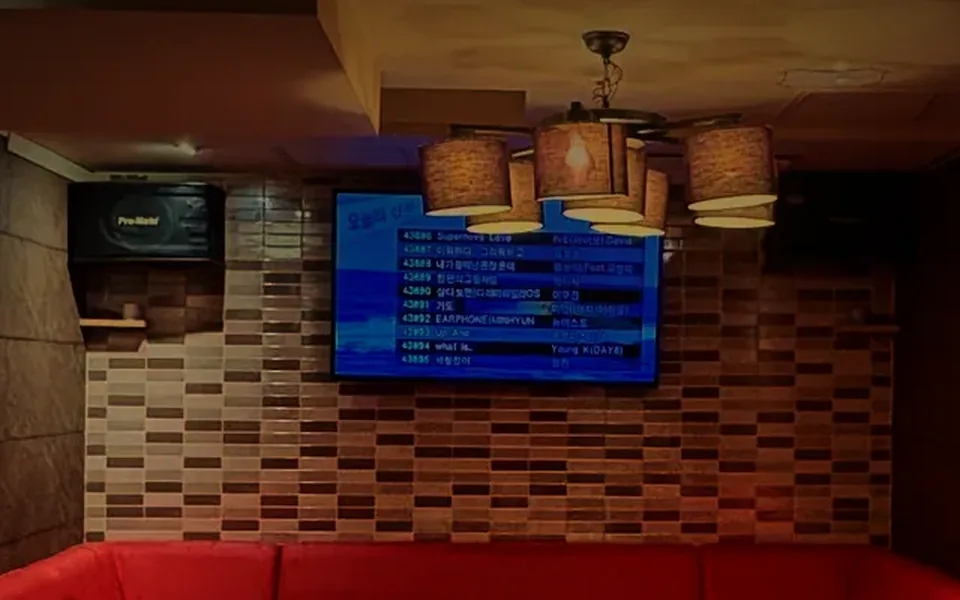 VIP room at Running Rabbit, Gangnam: red banquette, karaoke screen and pendant lights